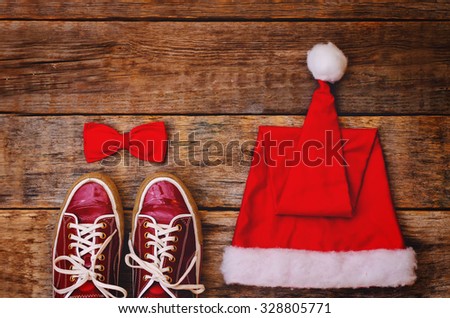 wood background with sneakers red hood and a bow. toning. selective focus