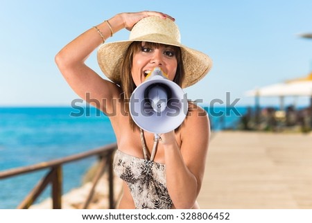 Woman in bikini shouting by megaphone  