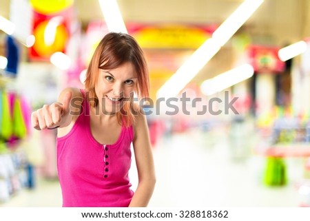 Pretty young girl with thumbs up on unfocused background