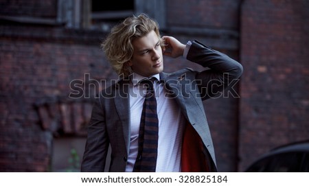 young businessman in a gray suit, business style,  portrait on the wall background