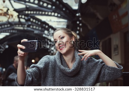 Portrait of a smiling beautiful young woman making selfie photo with her smartphone