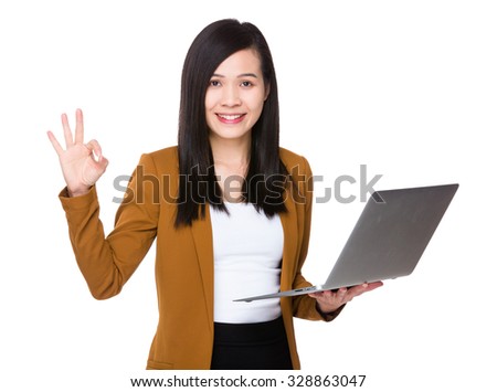Asian businesswoman use of the laptop computer and ok sign gesture