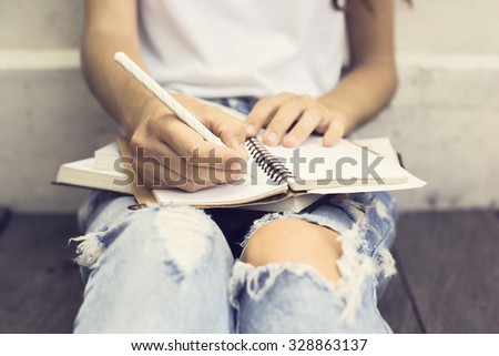 Gir with booksl writing in the diary Royalty-Free Stock Photo #328863137