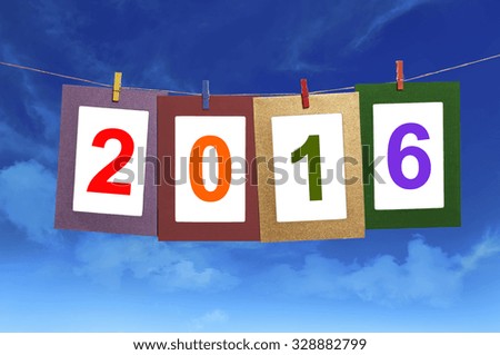 New year 2016 in photo frame hanging on clothesline with blue sky background