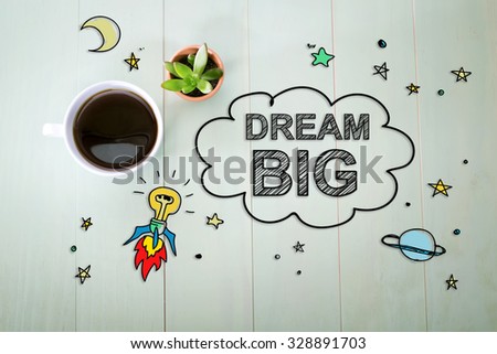 Dream Big concept with a cup of coffee on a pastel green wooden table