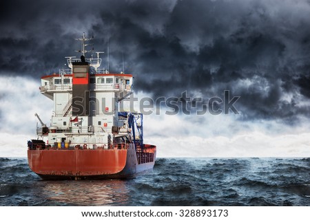 Cargo ship at sea during a storm. Royalty-Free Stock Photo #328893173