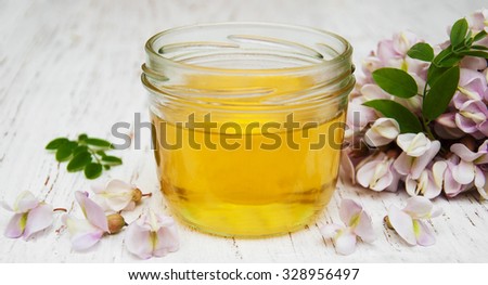 honey with acacia blossoms on a wooden background