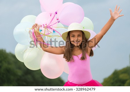 little girl running with balloons in her hand