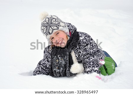 Little girl posing, isolated over a white background. Girl in the snow. The girl is lying in the snow.