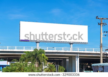 large blank billboard on overpass with city view background.