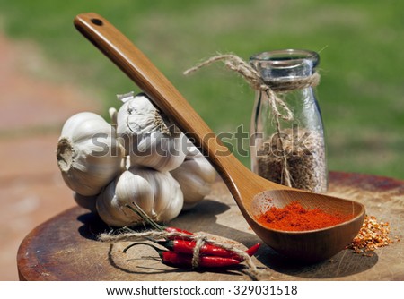 close up picture of a lot of red hot chilli peppers and spicy, garlic on wooden kitchen, curry