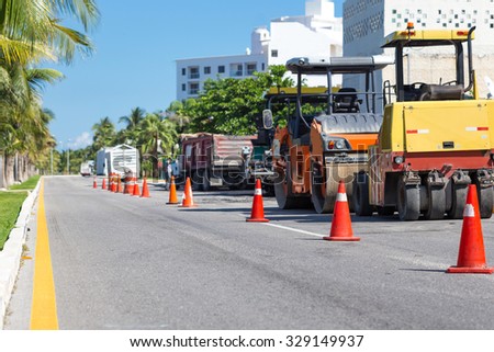 Road construction works. Traffic cones at tropical street warning about asphalt pavement works 
