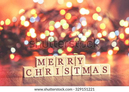 Defocused bokeh lights background with Merry Christmas text. Cross processed image with shallow depth of field