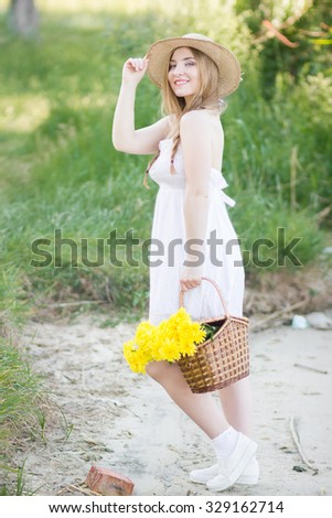 Closeup portrait of cute young girl with yellow flowers smiling outdoors. Soft focus