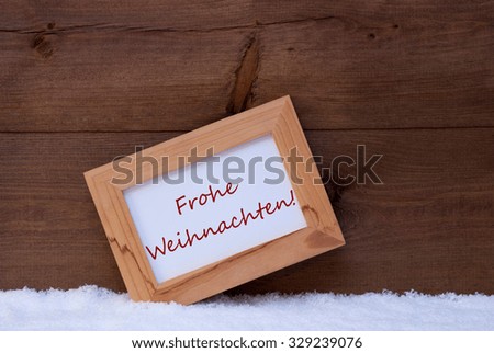 Brown Christmas Card With Picture Frame On White Snow. German Text Frohe Weihnachten Means Merry Christmas. Rustic Wooden, Retro Vintage Background