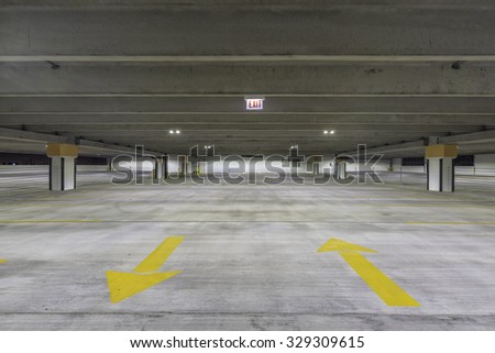 Empty parking garage with exit sign at night
