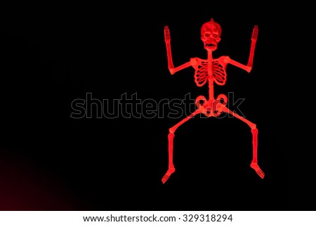 Red skeleton man jumping on black background