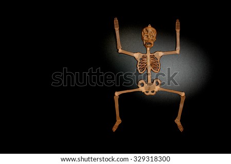 Brown skeleton man jumping  on shiny black background 
