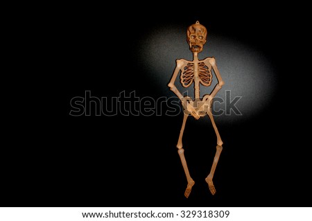 Brown skeleton man is in free kick mode on shiny black background 