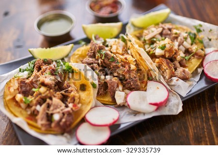 three street tacos in yellow corn tortilla with different meats