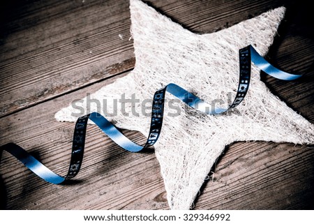 beautiful christmas decoration - white star and blue ribbon on the wooden floor
