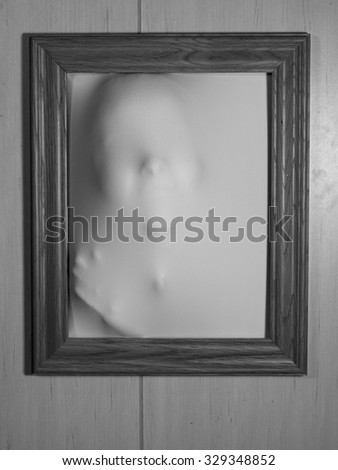 Creepy Bland and White Picture Frame with Something Coming Out of It
