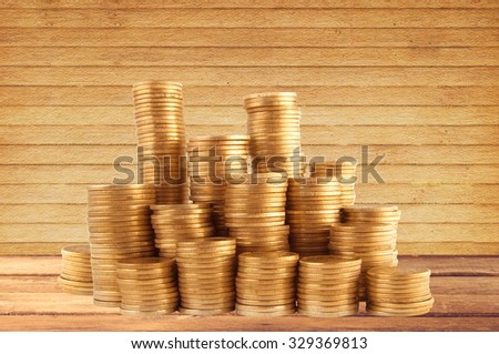Stacks of golden coins on wooden table background