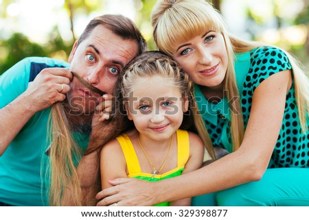 Young and beautiful family in the park. Mother, father and daughter