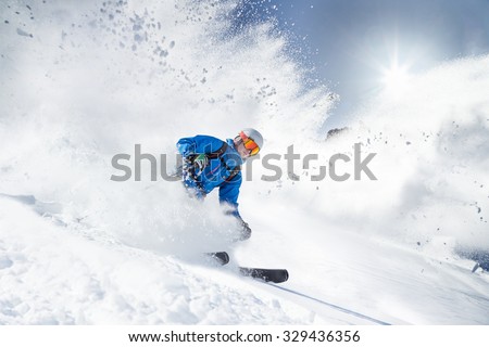 Skier skiing downhill in high mountains Royalty-Free Stock Photo #329436356
