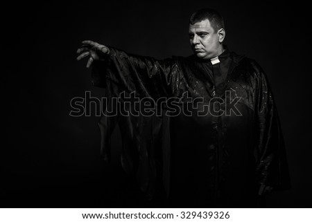 The priest during religious speech. Emotional black and white photography. Theatrical image of the priest. Professional makeup. Photo for religious magazines, websites, posters and backgrounds. 