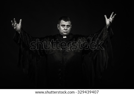 The priest during religious speech. Emotional black and white photography. Theatrical image of the priest. Professional makeup. Photo for religious magazines, websites, posters and backgrounds. 