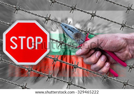 Hungary flag, STOP sign, migrants and barb wire with pliers
