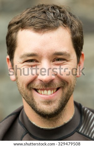 A close-up image of a man's wet face with hair stuck to his forehead, looking up with a real and intense expression. Royalty-Free Stock Photo #329479508