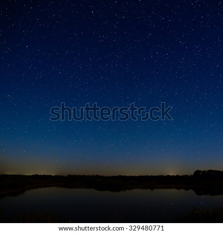 The stars in the night sky. Night landscape with a smooth surface of the river.