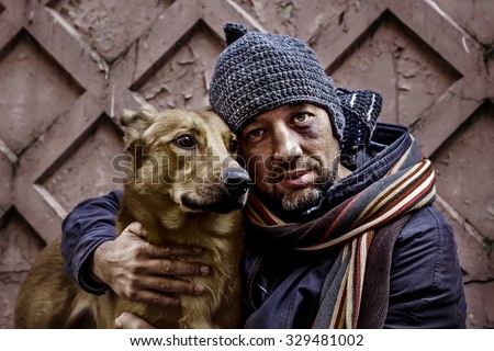 Portrait of dirty tramp hugging his dog. Image with toning and selective focus Royalty-Free Stock Photo #329481002