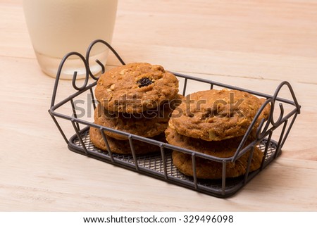 stack of cookies and glass of milk on wooden background (selective focus on cookies)