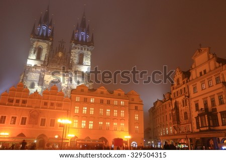 Prague Old Town main square and Gothic church in the background in foggy autumn night, Czech Republic