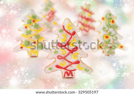 Cookies in the shape of a Christmas tree decorated with cream and colored sugar