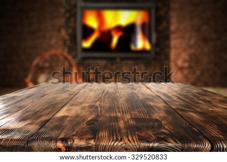 dark wall with black fireplace with wooden table place 
