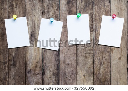 White note with pin on wooden background