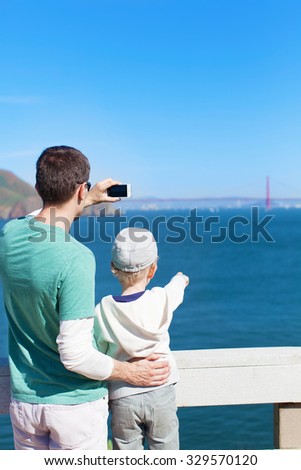 family of two enjoying gorgeous view at golden gate bridge in san francisco - famous sightseeing place and taking a picture of it
