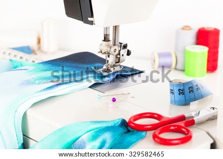 Sewing machine and fabric with scissors and threads