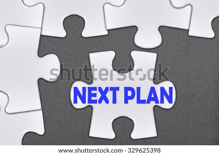 The white jigsaw puzzle written word next plan.