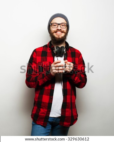food, happiness and people concept: young bearded man with a cup of coffee against grey background