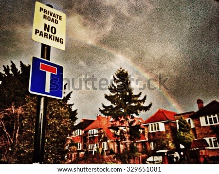 Private road sign with rainbow in sky