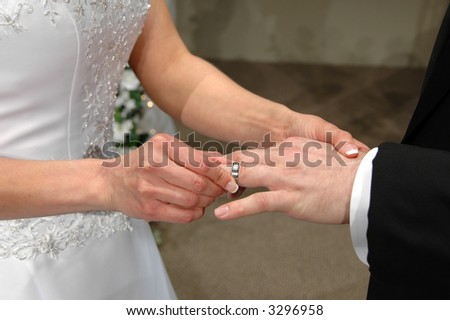 The bride inserting a ring into the bride's finger
