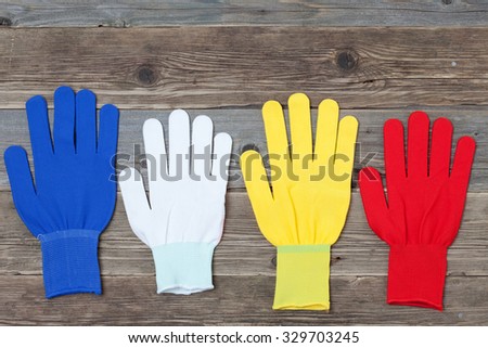 four new working colored gloves on a old wood boards