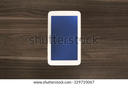 Digital tablet computer or smartphone phone on old wooden desk. Simple modern mobile workspace or web surfing. Vignette light effect. Blue color on screen. Lot of free spare copyspace for your content