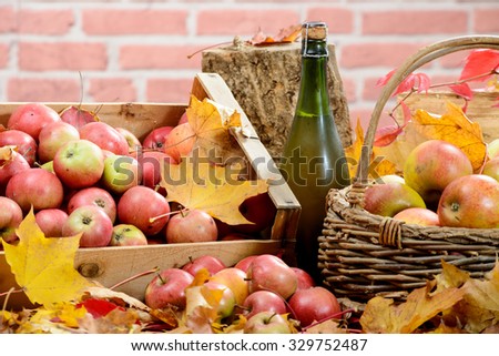 a bottle of Normandy Cider, with many apples and basket