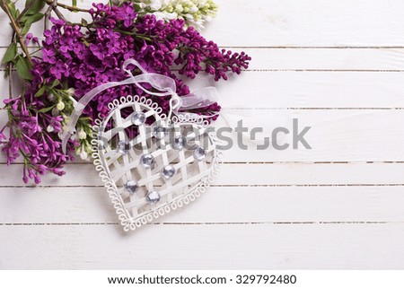 Decorative  heart and  white and violet lilac flowers on white painted wooden planks. Selective focus. Place for text.